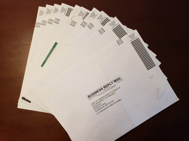 Photograph of fanned pre-printed course packet return envelopes.