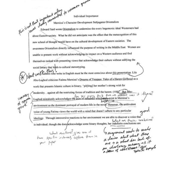 A paragraph of student-written text with handwritten directive teacher comments provided in-line and marginally. 